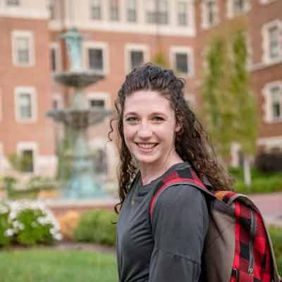 A student poses for a photo on campus